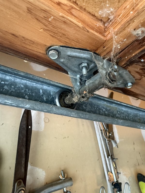 Worn garage door roller and hinge bracket before service