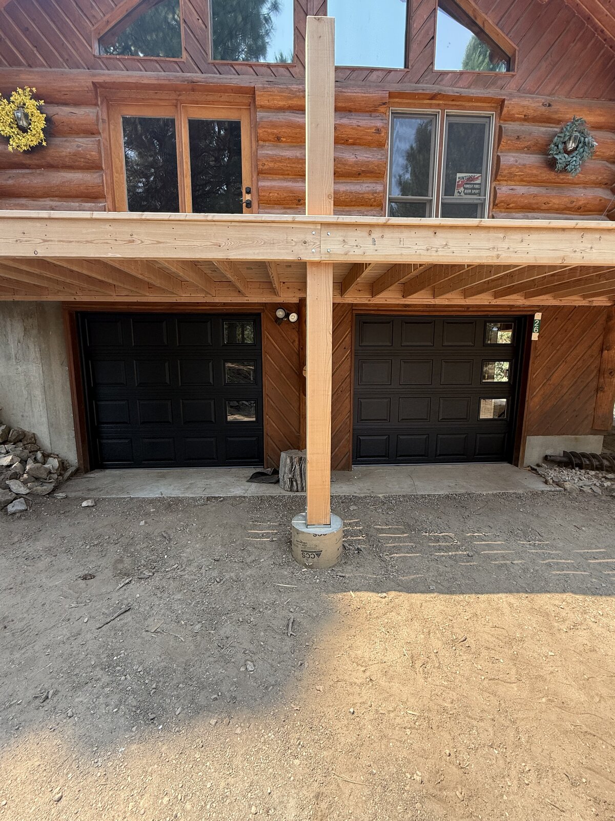 Two new black garage doors installed on a log cabin home in the Treasure Valley, Idaho